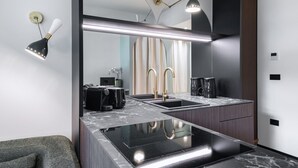 Une cuisine moderne dotée d’un grand îlot central, d’appareils électroménagers en acier inoxydable et d’un élégant pare-feu.