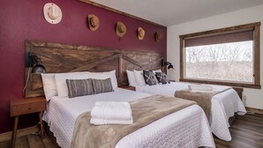 A double room with two beds, wooden headboards, a large window, and a red accent wall. - Double the Comfort | Travel Together (Prescott)