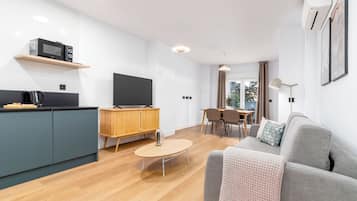 A modern living space with a kitchen, dining area, and seating area.