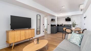 One-Bedroom Comfort Apartment + Balcony | Living area | 50-inch flat-screen TV with cable channels