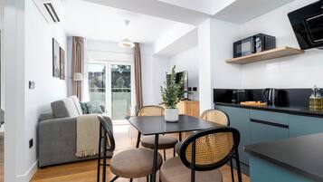 One-Bedroom Junior Apartment + Balcony | Living area | 50-inch flat-screen TV with cable channels