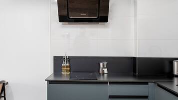 A modern kitchen with a built-in microwave, a coffee maker, and a cabinet.