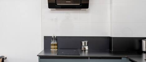 A modern kitchen with a built-in microwave, a coffee maker, and a cabinet.