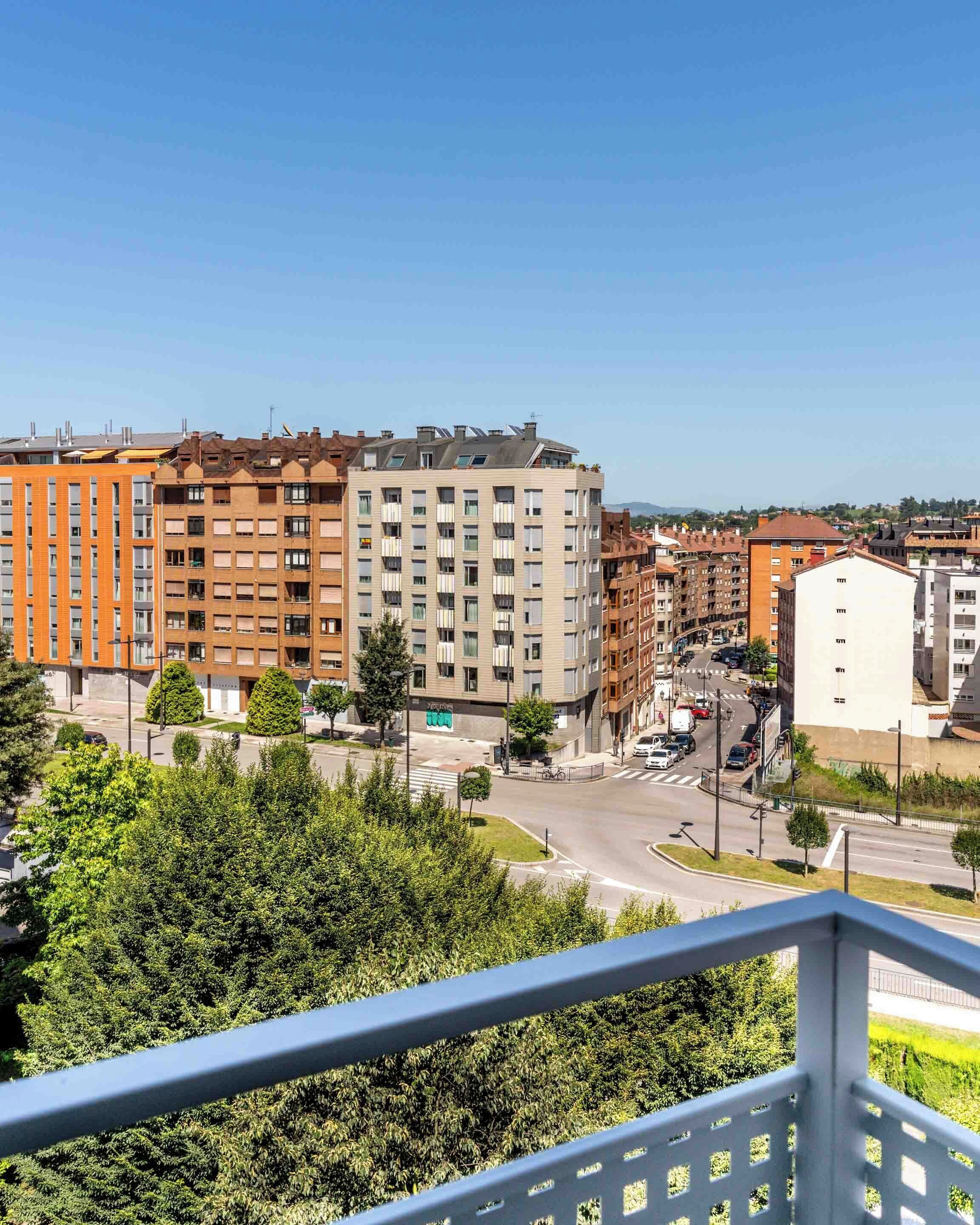 A multi-story residential building with a modern design, featuring balconies and a mix of window styles.