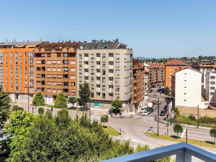 A multi-story residential building with a modern design, featuring balconies and a mix of window styles.