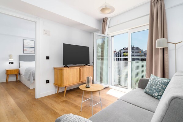 One-Bedroom Apartment with Balcony | Living area | 50-inch flat-screen TV with cable channels