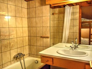 A bathroom with a bathtub, a shower, and a double sink with a mirror above. - Studio-Duplex for 6 in Morzine, Parking Included (Morzine)