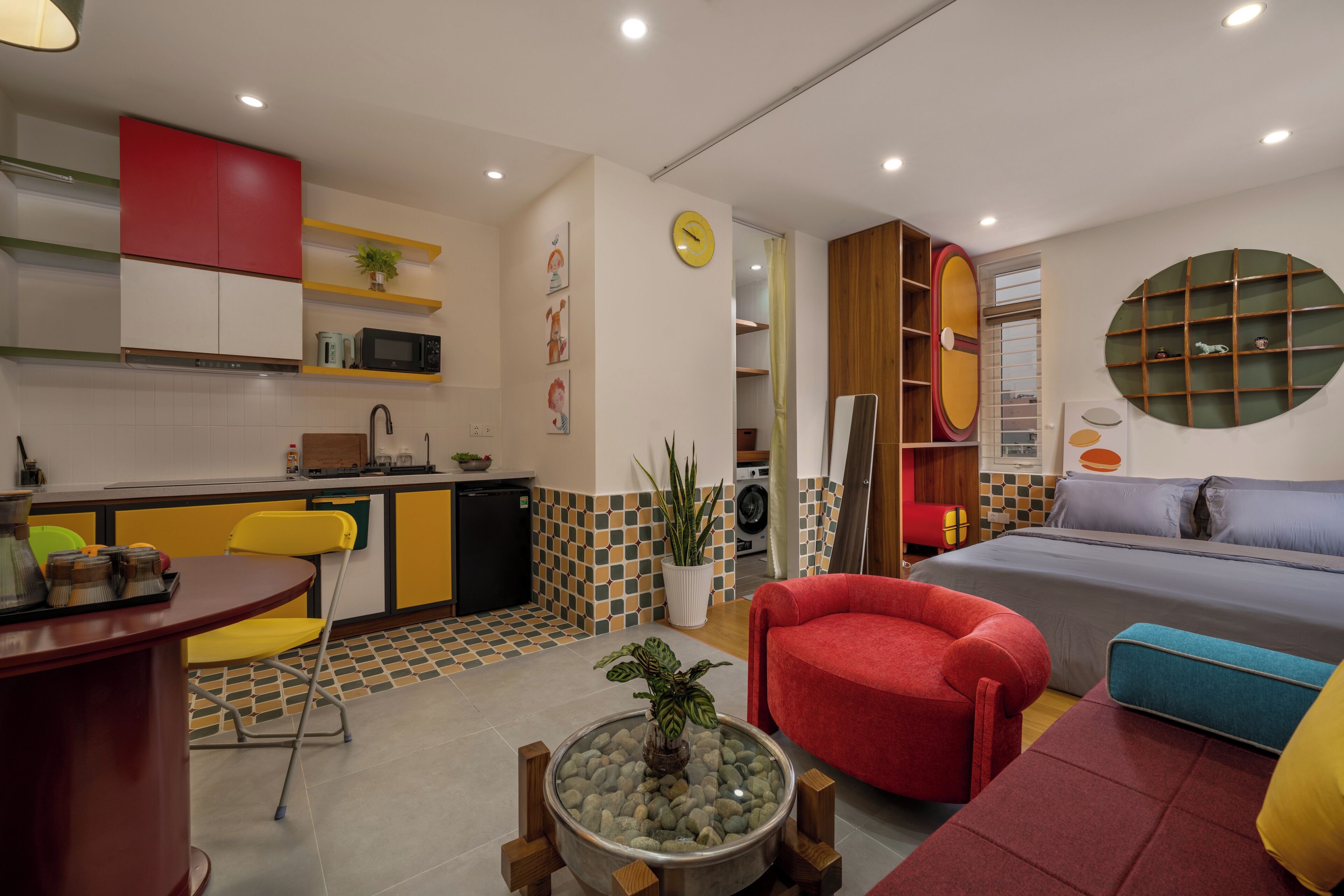 A compact living space with a kitchenette, a dining area, and a bedroom.