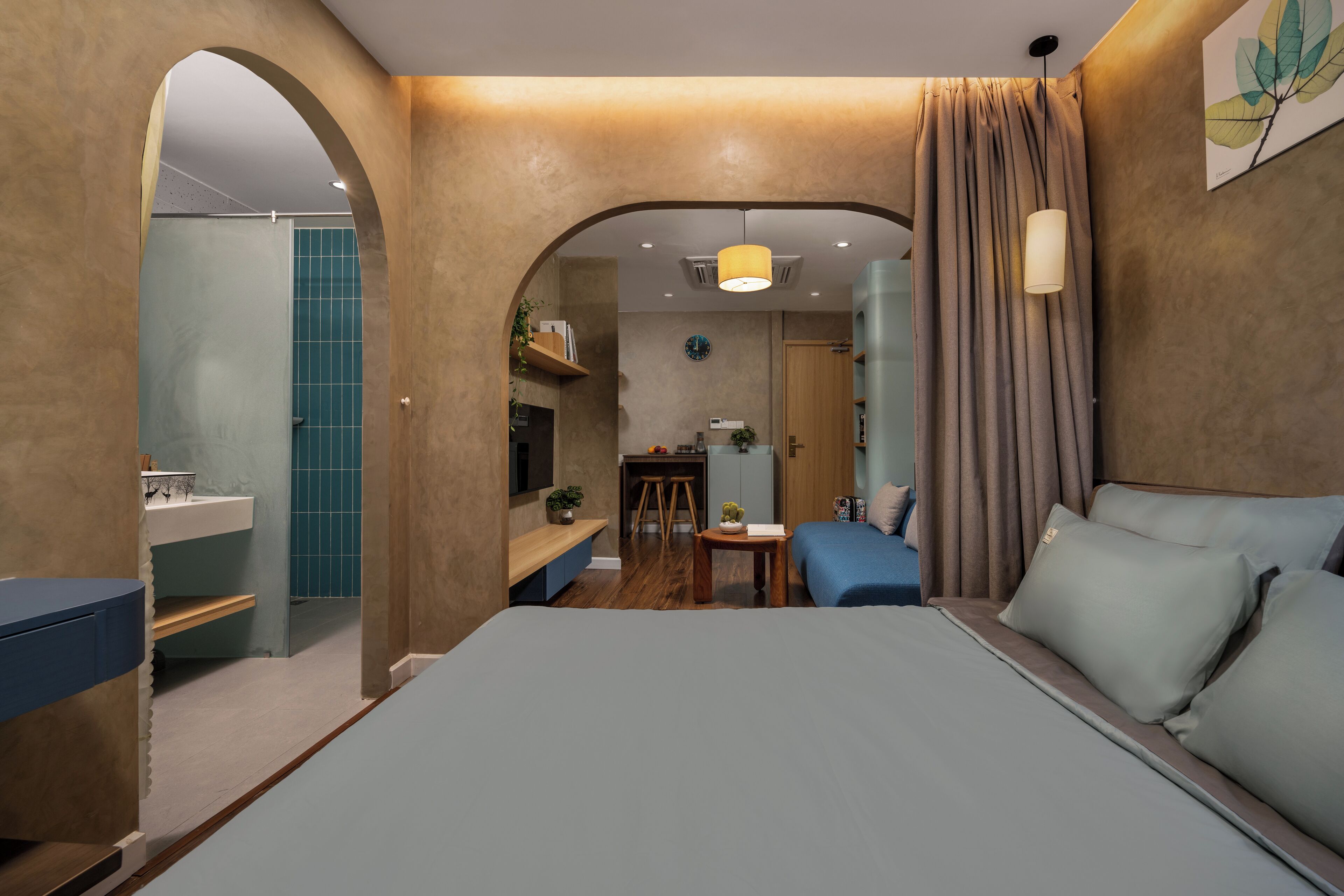 Una habitación de hotel moderna con una cama grande, un escritorio y una zona de ducha.