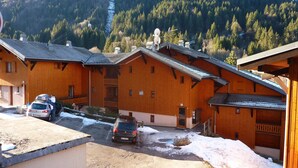 A row of wooden cabins with a ski lift in the background. - Renovated studio by the cable car, parking, WiFi (Morzine)