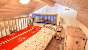 A cozy bedroom with a wooden ceiling, a bed with red and white bedding, a nightstand, and a wooden dresser. - Renovated studio by the cable car, parking, WiFi (Morzine)