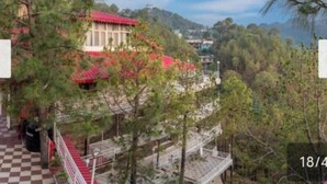 A building with a red roof, surrounded by trees and hills. - JP Restaurant And Resort (Solan)