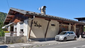 A building with a sign reading "Val d'Aulps" and a parked car.