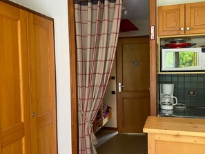 A kitchen with wooden cabinets, a microwave, and a coffee maker.