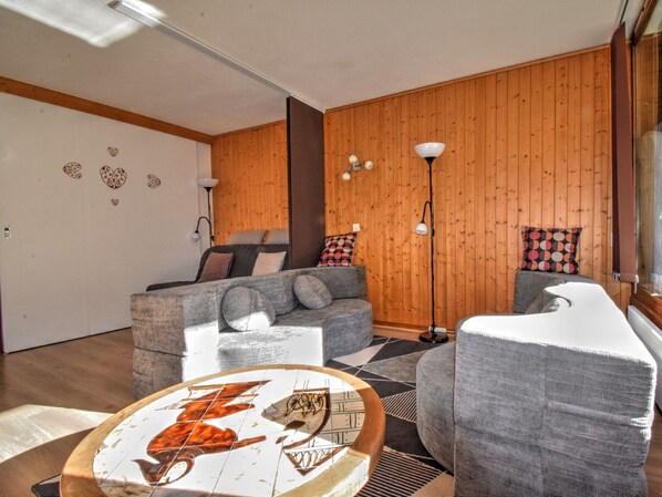 Un salon chaleureux avec un canapé, un fauteuil et une table décorative.