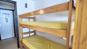 A bunk bed with a yellow mattress in a room with white walls and a door. - Studio with southwest-facing balcony, parking, pets allowed, 300m from center (Morzine)