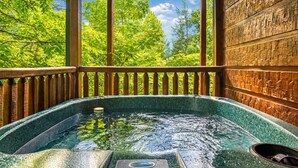 A hot tub with a wooden deck and a view of trees. - It's 5 O'clock Somewhere: Hot Tub, Theater Room, Free Tickets, Game Room!!! (Gatlinburg)