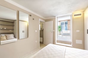 A bedroom with a large bed, a wardrobe, a mirror, and a window with a view of the outside. - Seaside Home where Villasimius's sea becomes home (VILLASIMIUS)