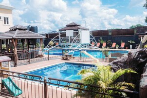 Una piscina al aire libre, camas de piscina gratis, sombrillas