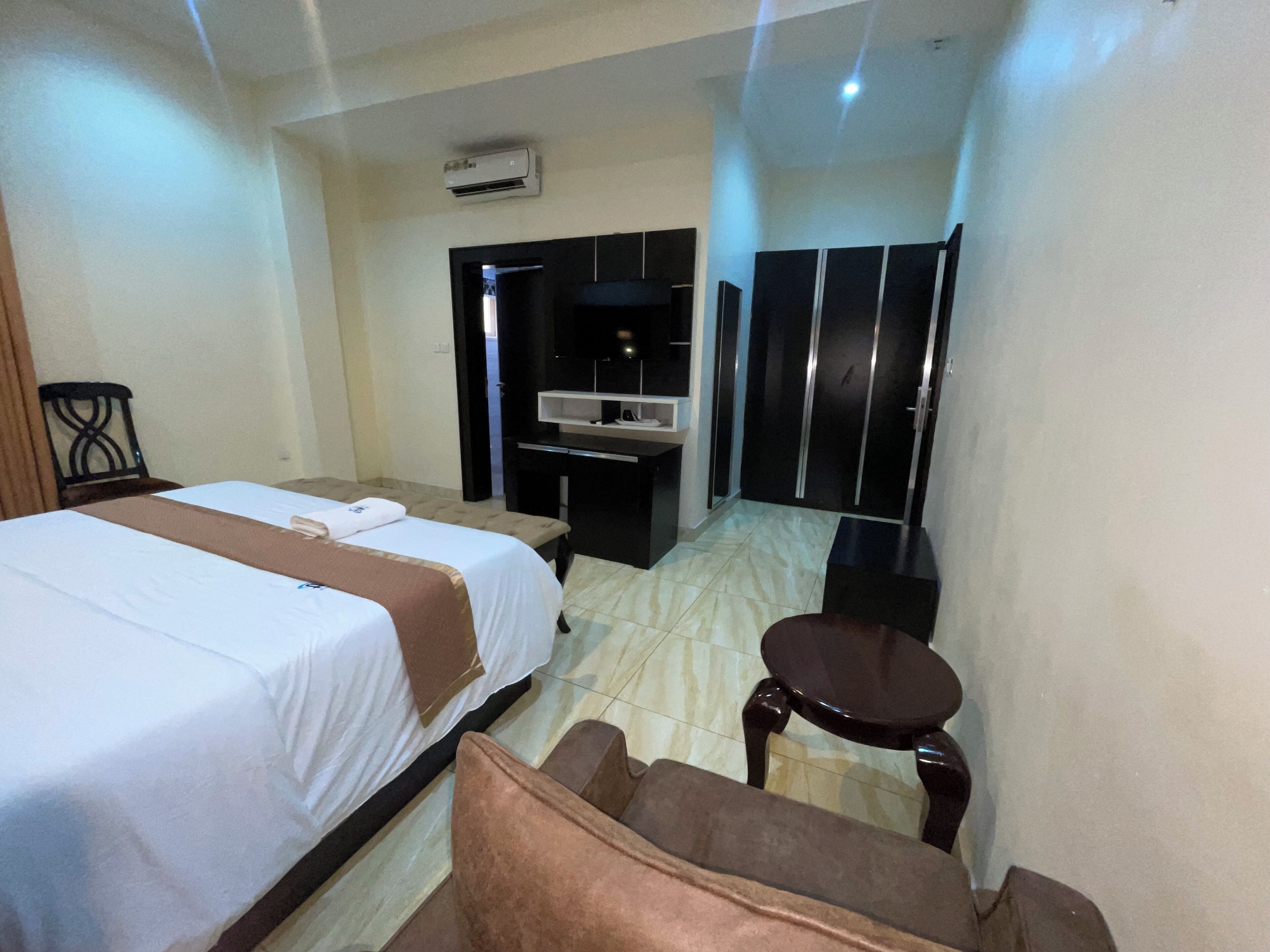Una habitación de hotel con dos camas, un escritorio, una silla y un armario.