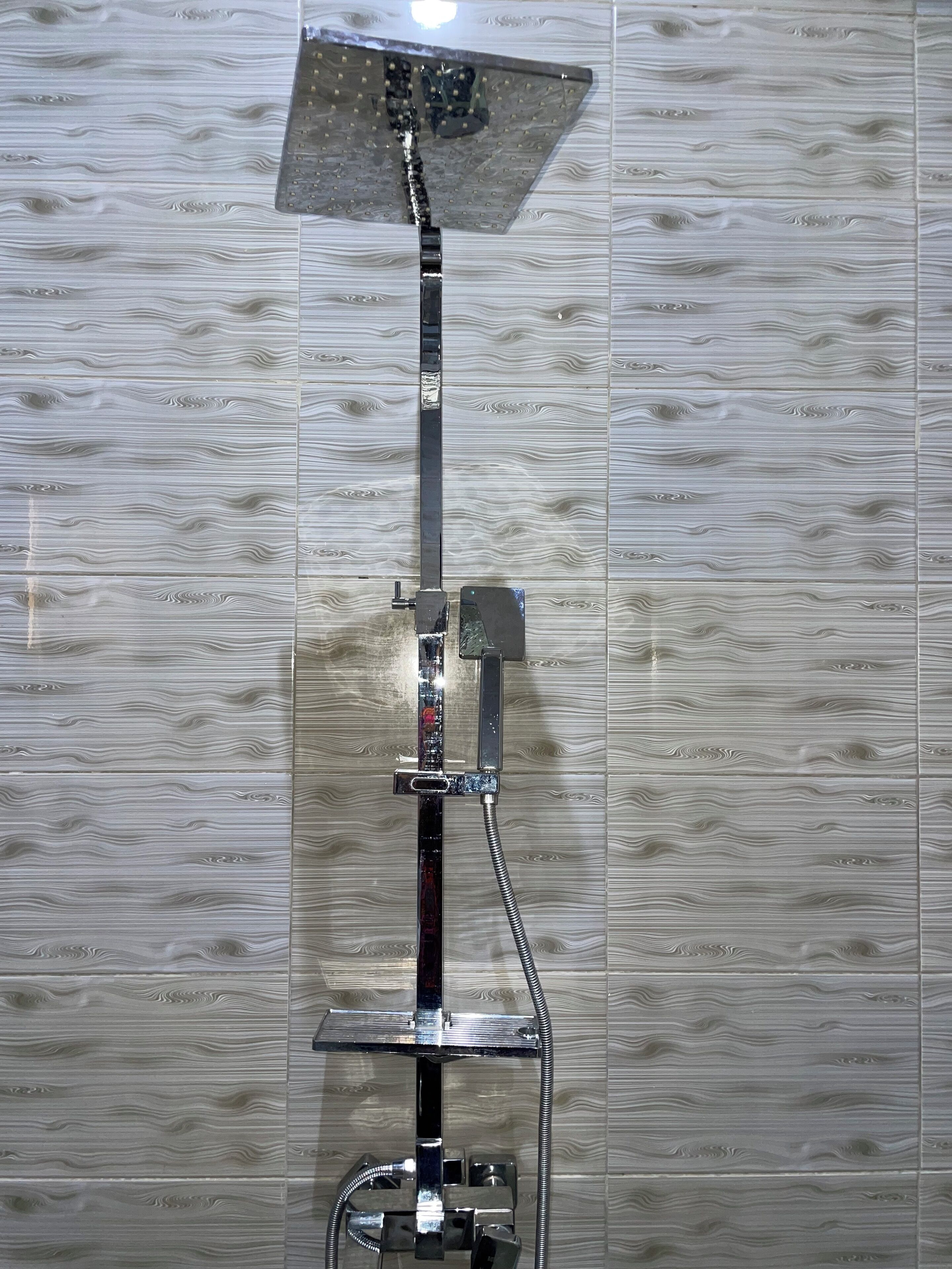 A shower with a square head and a handheld attachment.