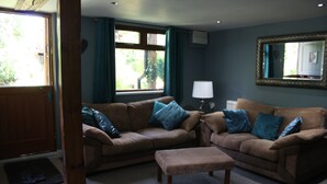 A living room with two sofas, a coffee table, and a lamp.
