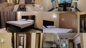 Une chambre d’hôtel comprenant un lit, un canapé, une table à manger avec des chaises, un coin cuisine et une salle de bain.