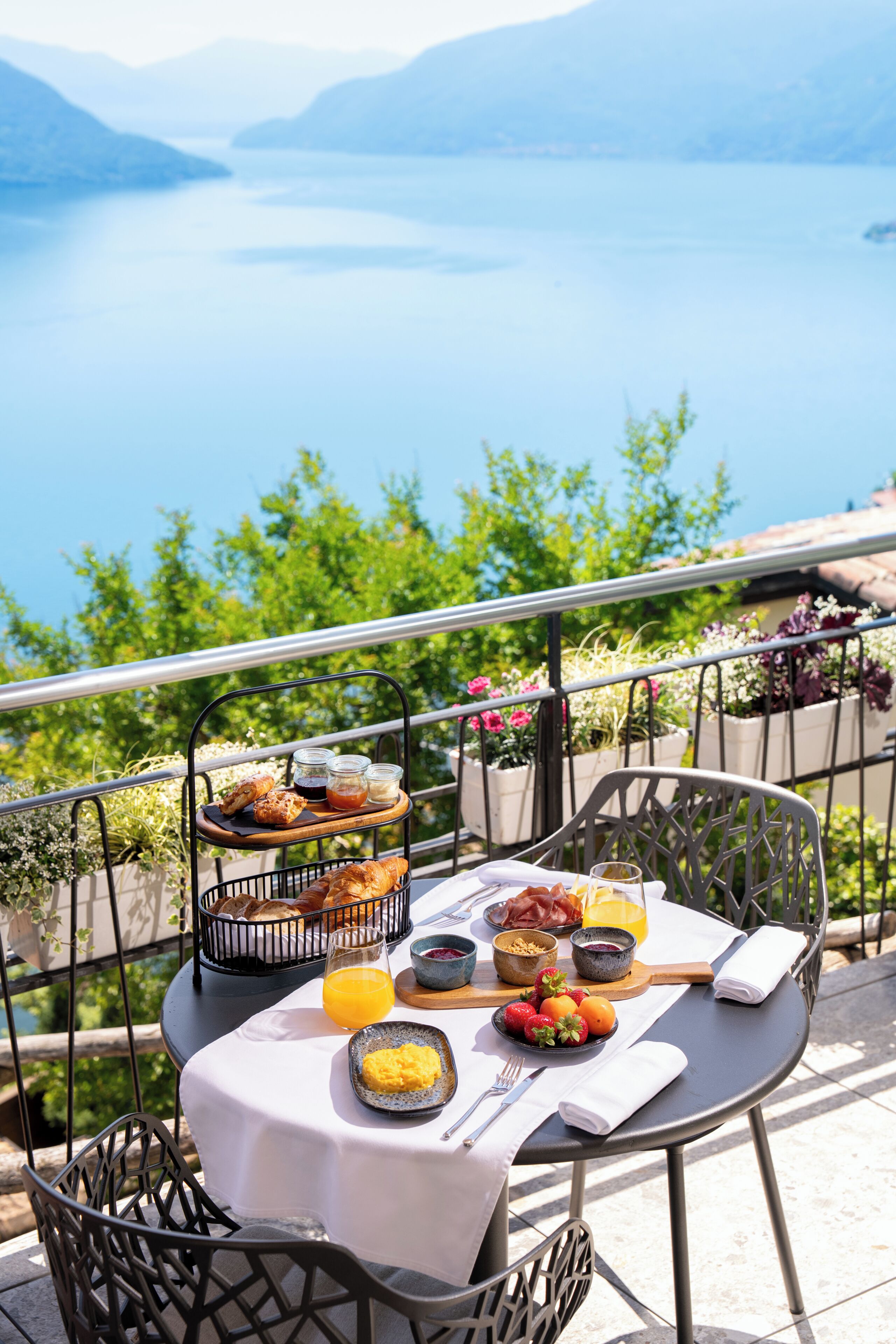 A table set with breakfast items overlooking a lake.