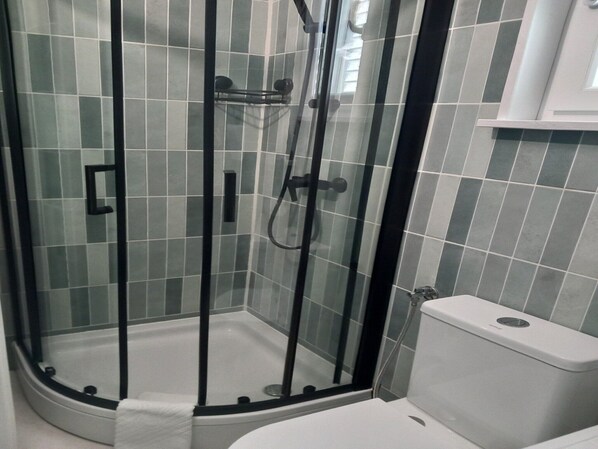 A corner shower with a glass door, a white toilet, and a tiled wall. - Guest House Green Corner Supetarska Draga (Rab)