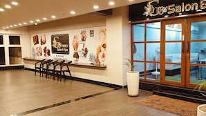 A salon & spa with a reception area, wooden flooring, and a large window. - PGC Chennai Resort & Club By SSS (Ponneri)