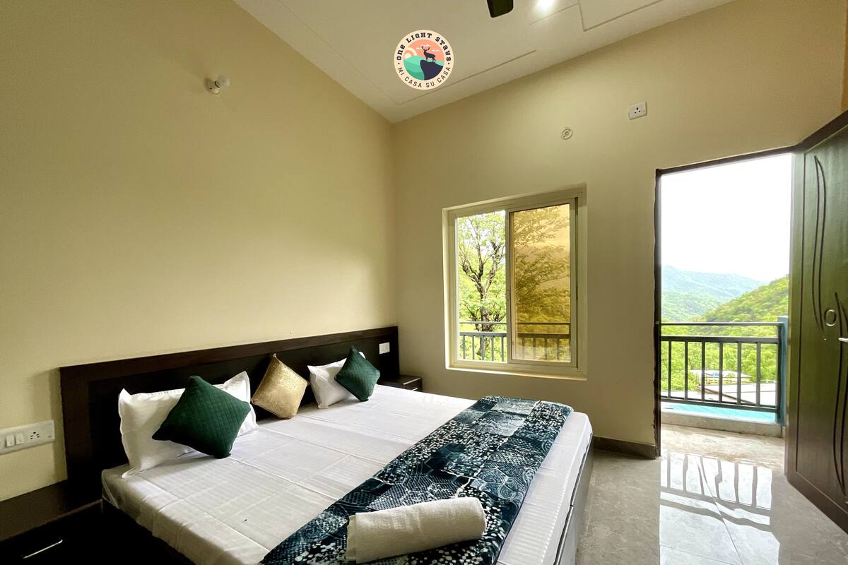 Ein Schlafzimmer mit einem Bett, Kissen, einem Fenster und einem Balkon.
