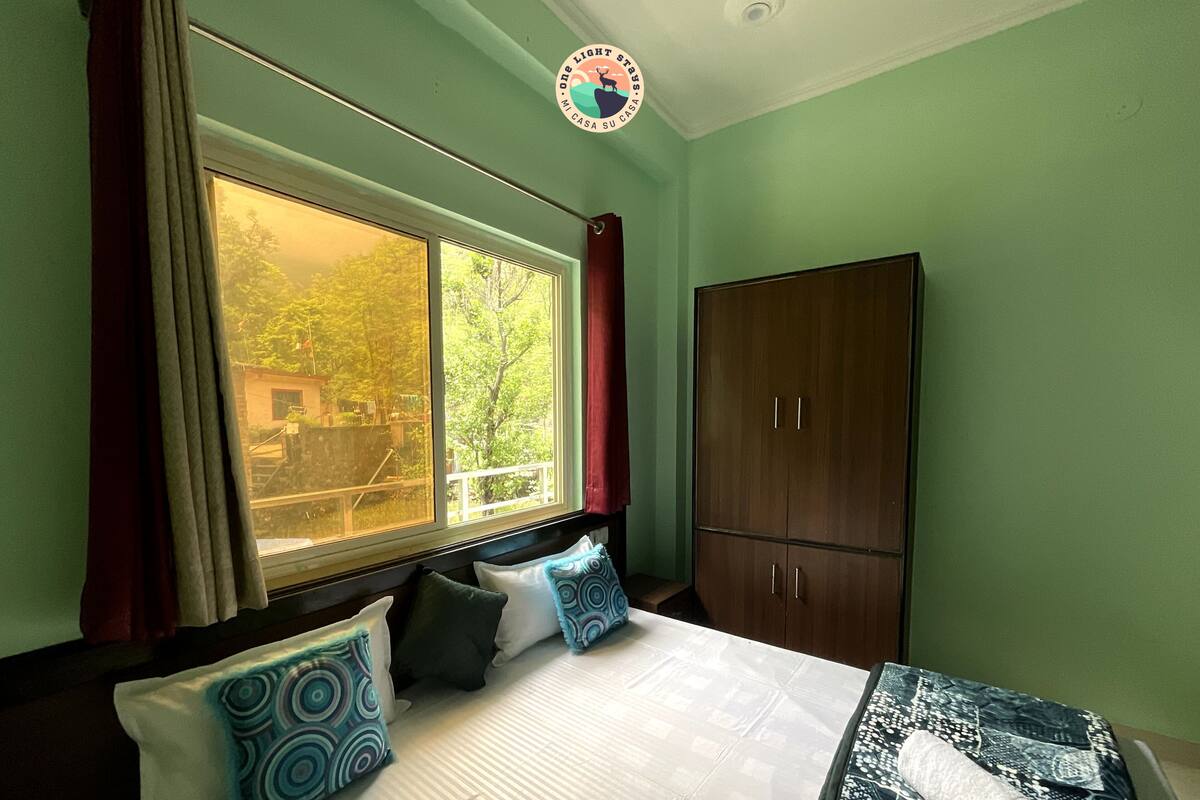 Ein Schlafzimmer mit einem großen Bett, einem Kleiderschrank und einem Fenster mit Vorhängen.