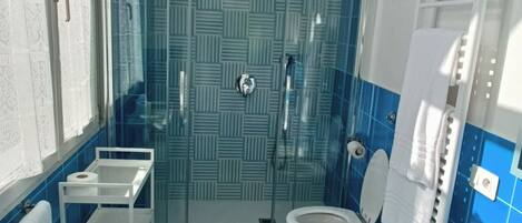 A bathroom with a shower, toilet, and sink.