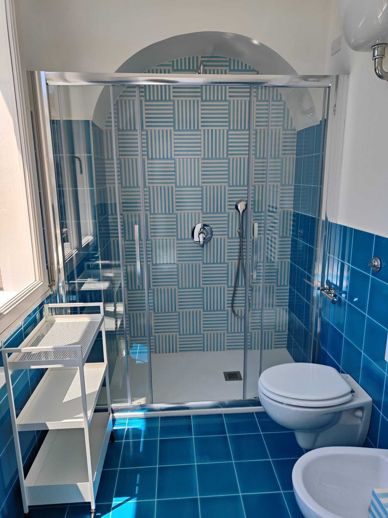 A bathroom with a shower, toilet, and sink.