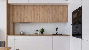 Una cocina moderna con armarios de madera, una encimera, un lavabo, una estufa y una planta.
