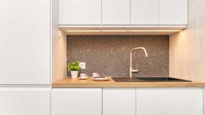 Eine moderne Küche mit Granit-Spritzschutz, einem Edelstahl-Wasserhahn und einer Holz Arbeitsplatte.