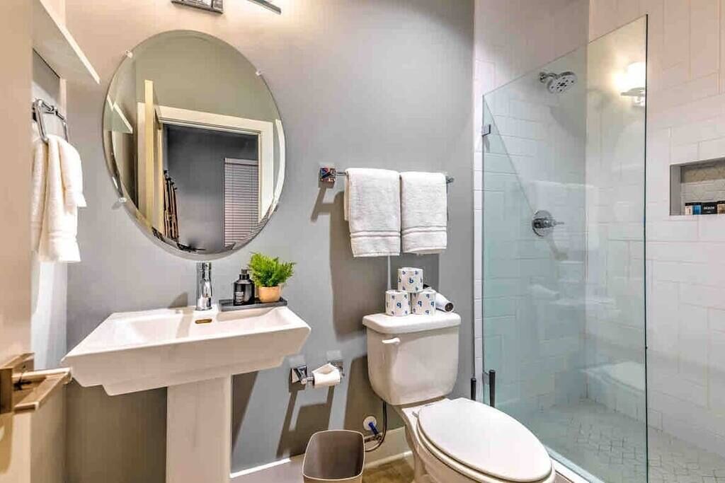 Un baño con lavabo, espejo, inodoro y ducha.