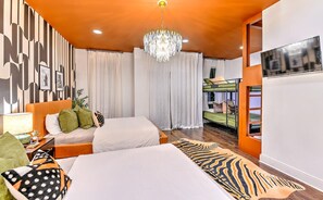 Ein modernes Hotelzimmer mit einem großen Bett, einer Kristallleuchter, einem Fernseher und Blick auf die Stadt.