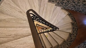 Una escalera de caracol con detalles de madera y barandilla de metal.