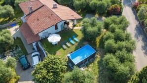 A two-story house with a swimming pool, a covered patio, and a garden. - Villa Ulivi private Pool & Lake View (San Felice del Benaco)