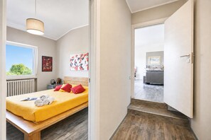 A bedroom with a bed, bedside table, and a window. - Villa Ulivi private Pool & Lake View (San Felice del Benaco)