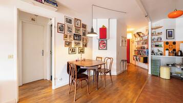 Een eetgedeelte met een houten tafel en stoelen, omgeven door muren versierd met ingekaderde foto's.