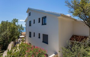 A two-story building with a white facade and dark window frames. - 2 bedroom nice apartment in Novi Vinodolski (Novi Vinodolski)