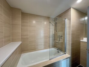Departamento Deluxe | Baño | Tina con regadera, regadera tipo lluvia, amenidades de baño gratuitas