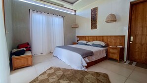 A bedroom with a wooden headboard, a bed with white and gray bedding, two bedside tables with lamps, a wooden wardrobe, and a large window with white curtains. - A private 200sqm entire villa, pool & rooftop with rice field view (Bali)
