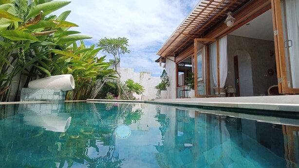 A clear swimming pool with a wooden pergola and a modern house with large windows. - A private 200sqm entire villa, pool & rooftop with rice field view (Bali)
