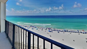 A beach view from a balcony with a railing, clear blue sky, and turquoise sea. - Edgewater Tower II #803 | Incredible Views + On-Site Pool & More! (Panama City Beach)