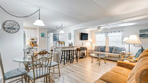 A well-lit living room with a sofa, chairs, a coffee table, and a dining area with a glass table and chairs. - 1/2 Mi to Ocean: Surfside Beach Resort Home (Murrells Inlet)