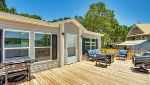 A deck with outdoor furniture, a grill, and a house with large windows and a door. - Cedar Creek Reservoir Home w/ Private Boat Ramp! (Kemp)