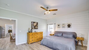 A bedroom with a large bed, wooden dresser, ceiling fan, and artwork on the wall. - Peaceful Vinita Home w/ Fire Pit: 11 Mi to Lake! (Vinita)